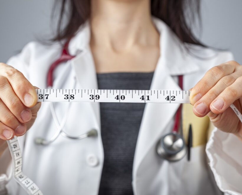 doctor with tape measure highlighting abdominal circumference