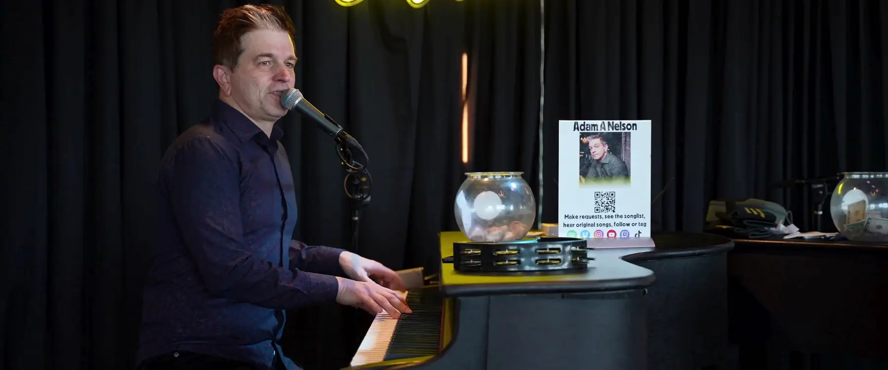 Adam Nelson singing and playing piano during a live performance