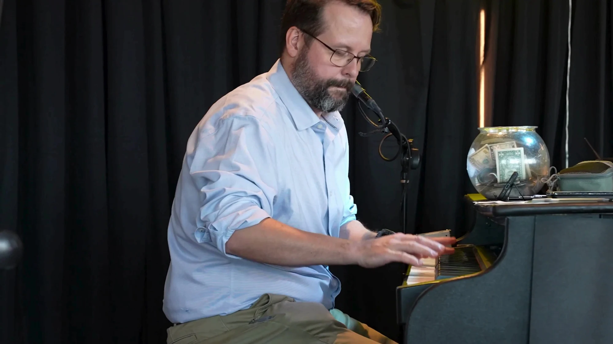 Adult pianist performing at a microphone during a Midwest Dueling Pianos show