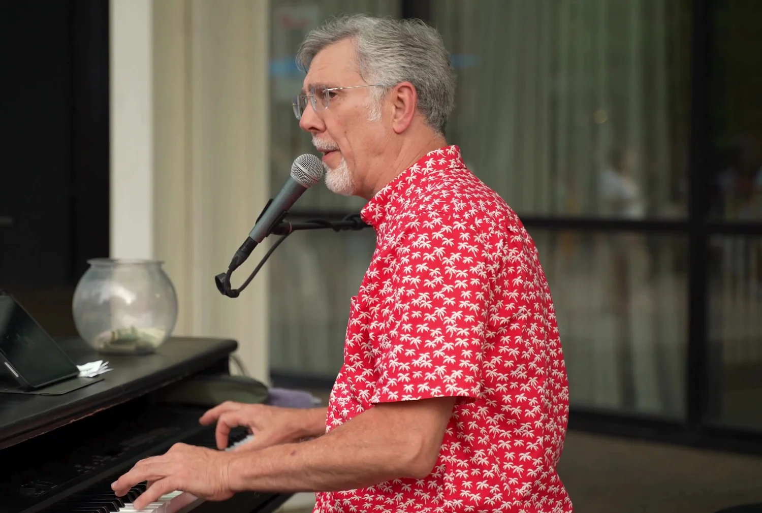 Adult piano performer singing into a microphone