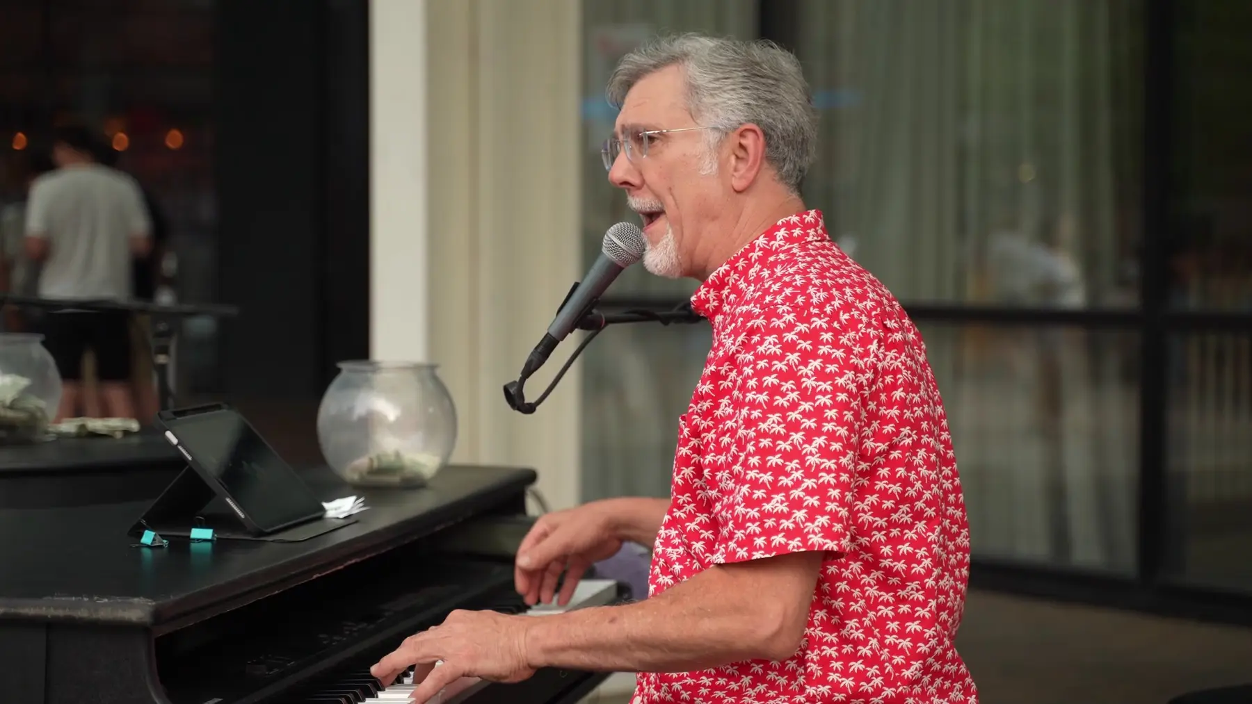 Robert Bozaich singing and playing piano at an outdoor performance